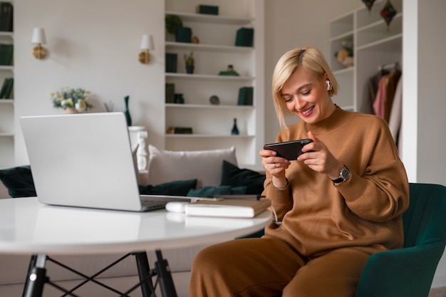 Foto gratuita donna di vista laterale che gioca con il suo telefono