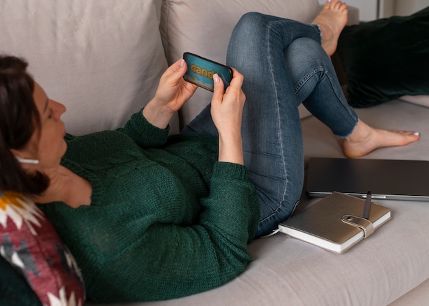 Foto gratuita donna di vista laterale che gioca con il suo telefono