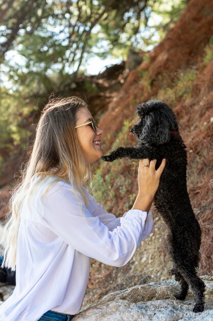 Side view woman playing with poodle