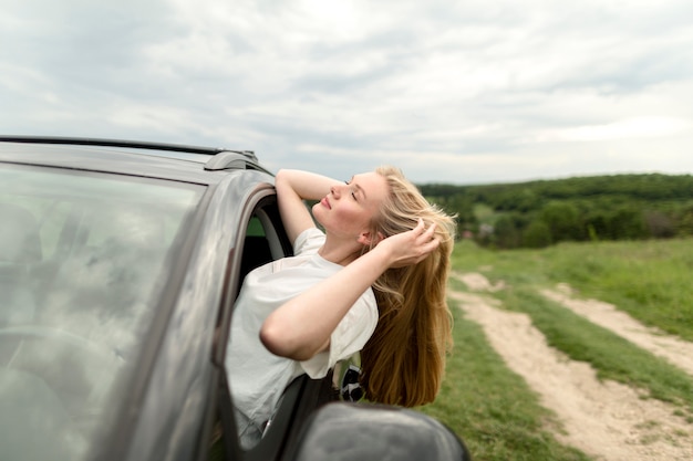 Free photo side view of woman posing in the car