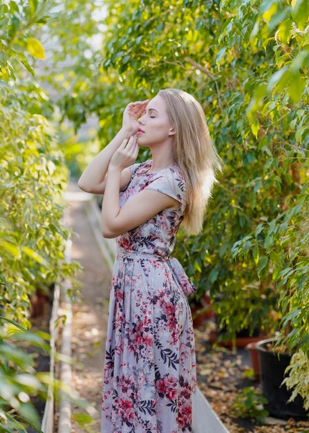 Side view woman posing in the middle of foliage