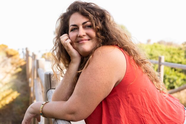 Side view of woman posing outdoors and smiling