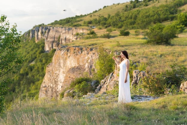 side view of woman posing outdoors with mountain