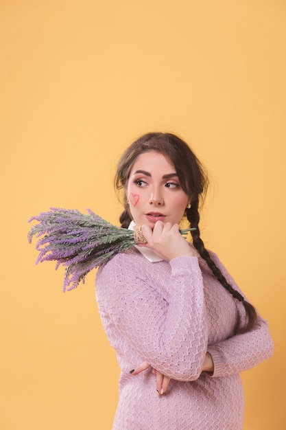 Side view of woman posing while holding lavender