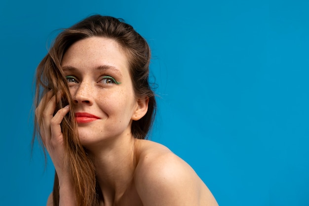 Foto gratuita donna di vista laterale in posa con sfondo blu
