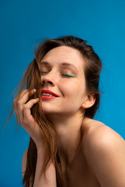 Side view woman posing with blue background