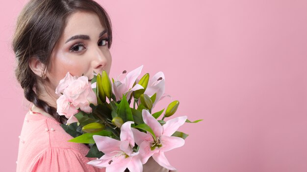 ユリの花束とポーズの女性の側面図