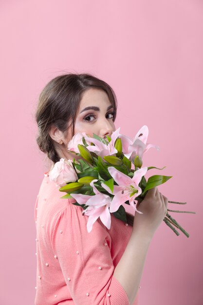Side view of woman posing with bouquet of lillies