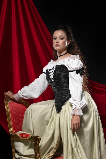 Free photo side view woman posing with chair  in studio