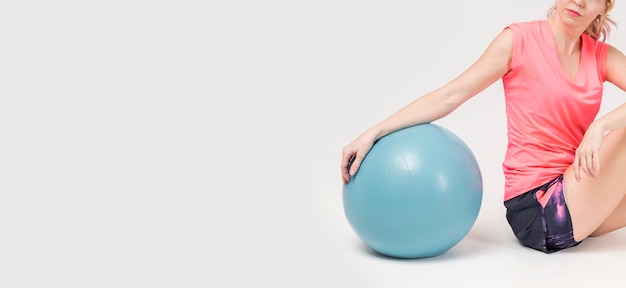 Side view of woman posing with exercise ball and copy space