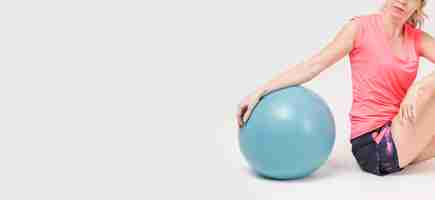 Free photo side view of woman posing with exercise ball and copy space
