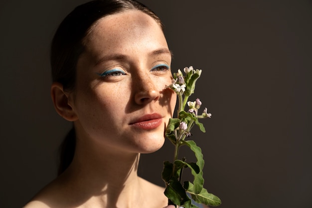 Free photo side view woman posing with flower