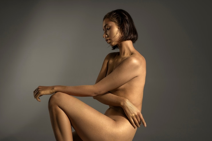 Free Photo side view woman posing with gold body painting
