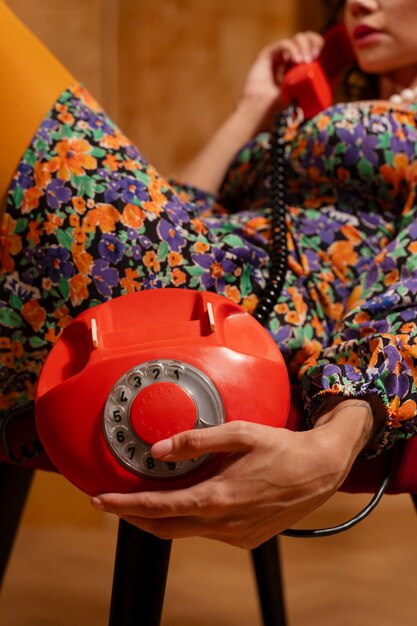 side view woman posing with old phone