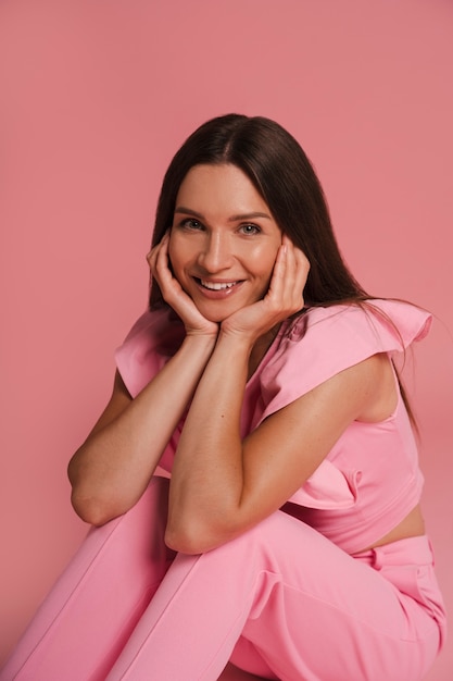 Free photo side view woman posing with pink outfit