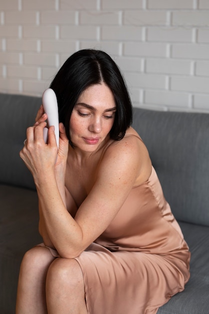 Side view woman posing with vibrator