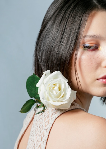 Side view of woman posing with white rose