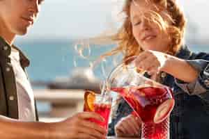 Free photo side view woman pouring sangria