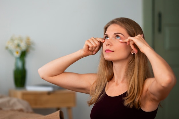 Free photo side view woman practicing facial yoga