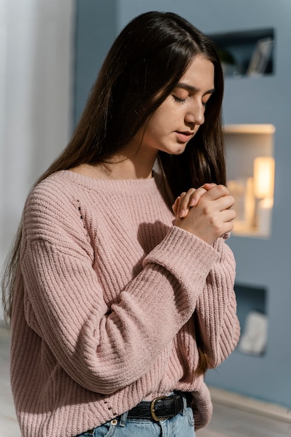 家で祈る女性の側面図