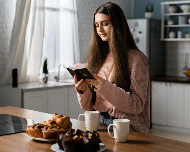 Side view of woman praying with bible