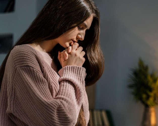 Женщина молится, вид сбоку