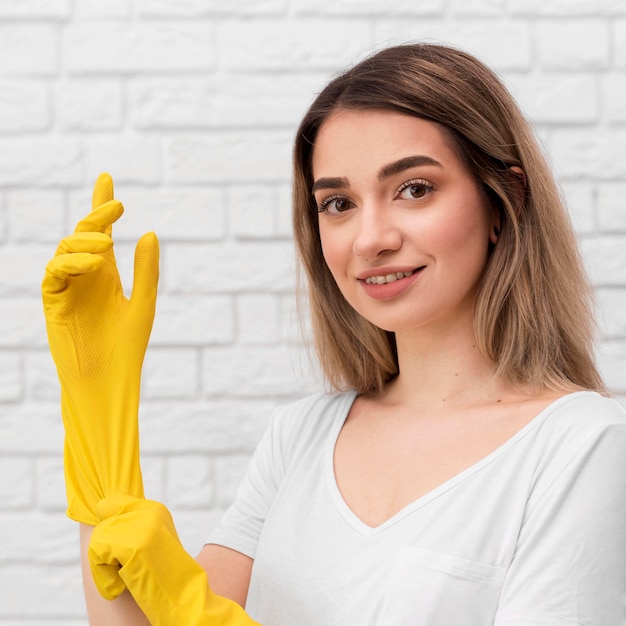 Side view of woman putting on cleaning gloves