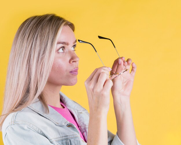 Side view woman putting glasses on