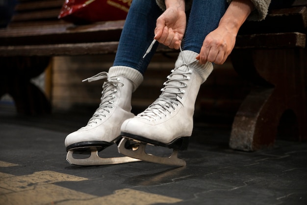 Side view woman putting on ice skates