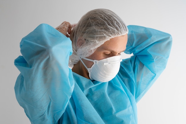 Side view woman putting on mask