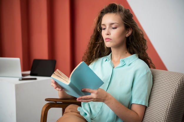 Free photo side view woman reading book