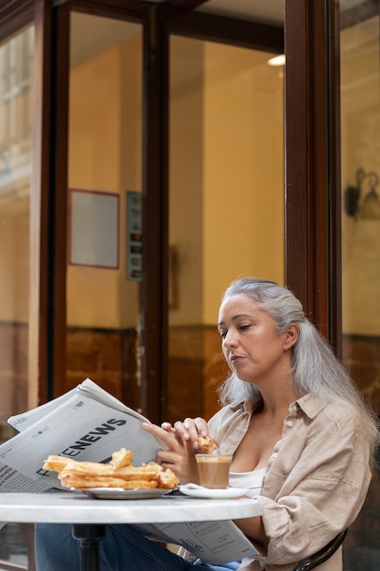 Side view woman reading the newspaper