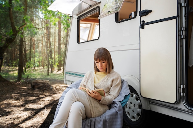 屋外で読んでいる側面図の女性