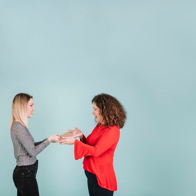 Side view woman receiving gift from daughter