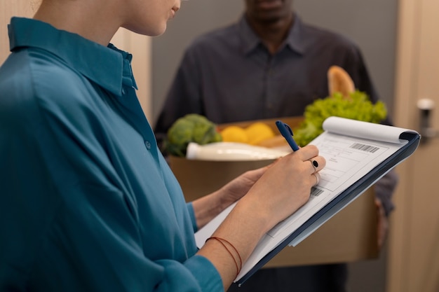 Free photo side view woman receiving groceries