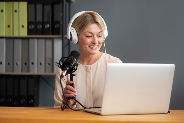 Side view woman recording podcast with laptop