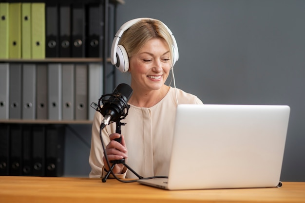 side view woman recording podcast with laptop