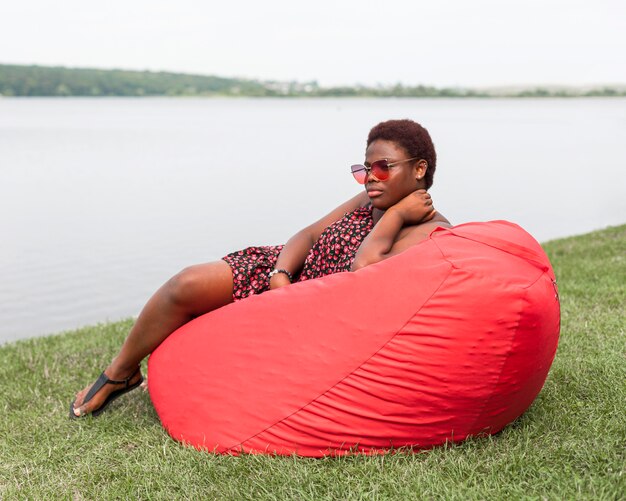 Side view of woman relaxing outside on bean bag