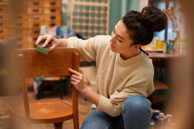 木製の椅子を復元する側面図の女性