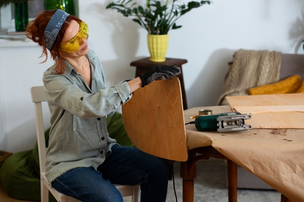 Free photo side view woman restoring wooden furniture