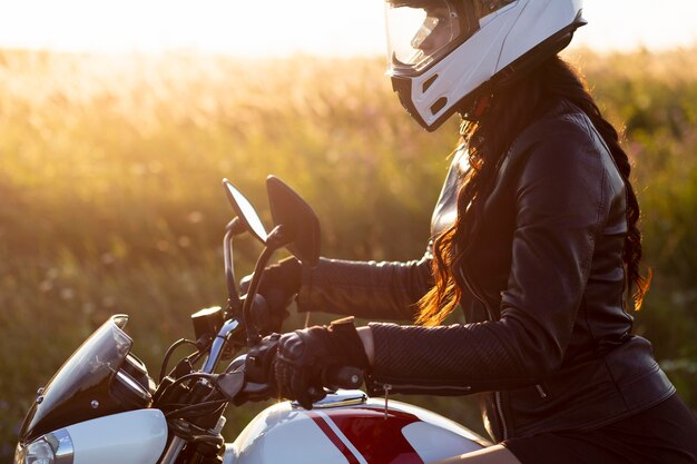 Side view of woman riding her motorcycle with helmet on