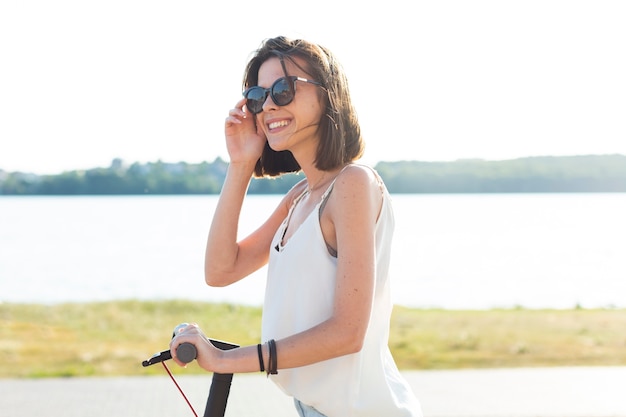 Side view woman riding a scooter