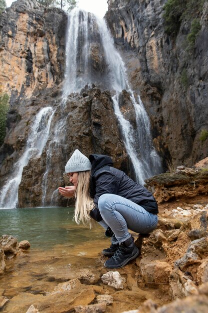 Side view woman at river drinking water