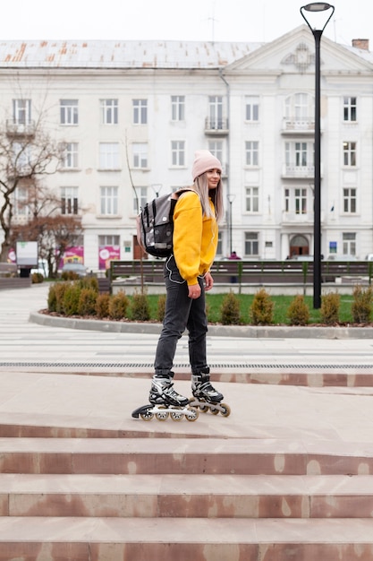 Free photo side view of woman rollerblading in the city