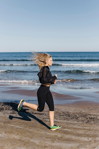 ビーチで走っている女性の側面図