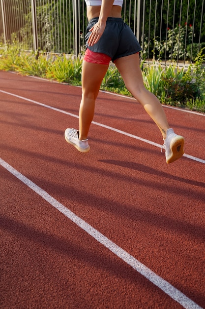 Free photo side view woman running on track