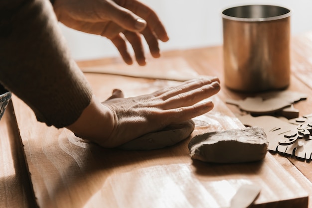 Side view of woman shaping clay