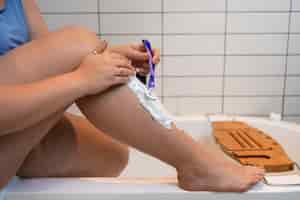 Free photo side view woman shaving at home