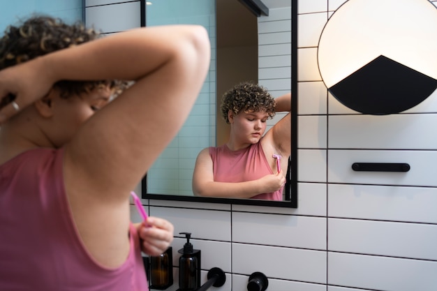 Free photo side view woman shaving at home