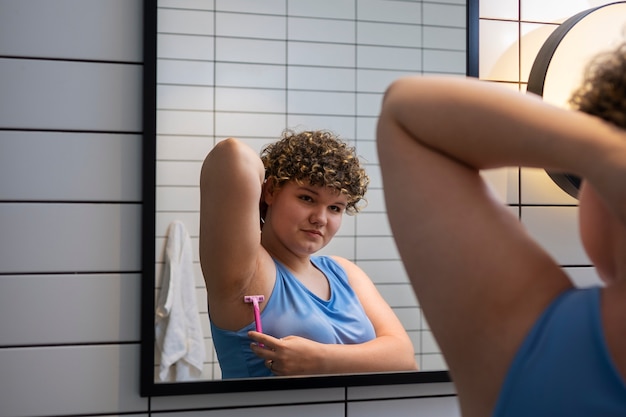 Foto gratuita donna di vista laterale che si rade a casa